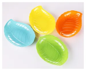 Close-up detail of cute leaf-shaped plastic candy and fruit snack plates in bright candy colors.