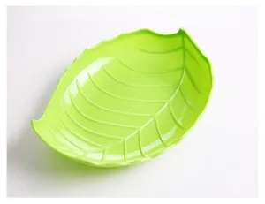 Green leaf shaped plastic fruit snack dish detail view, creative candy color design.