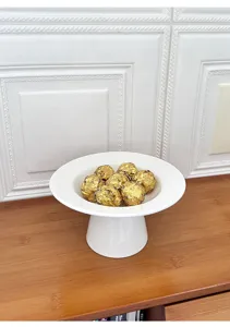 Detail view of modern minimalist white ceramic footed fruit plate and dessert display tray.