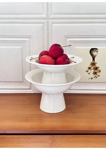White ceramic high-footed fruit plate detail, elegant tiered design for modern home decor dessert.