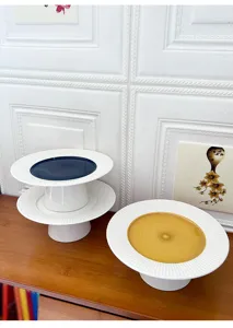 Detailed view of modern ceramic cake stand with radial texture and elegant high foot design.