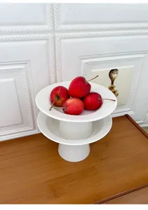 Detail view of modern minimalist white ceramic high-foot fruit plate and dessert tray for home.