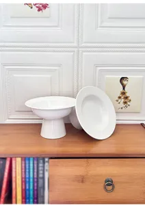 Modern minimalist white ceramic pedestal fruit plate dessert cake stand for home kitchen table.