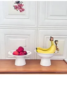 Detail scene display of modern minimalist white ceramic high foot fruit and dessert plate.