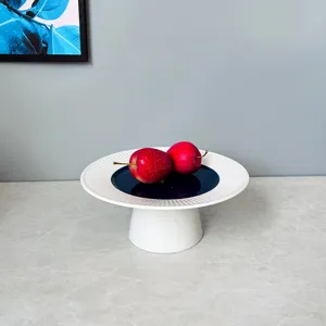 Modern minimalist ceramic cake stand with high base fruit plate for kitchen and cafe decor.