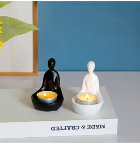 Porte-bougie minimaliste abstrait en résine, détail des figurines de méditation noir et blanc.
