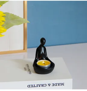 Vue détaillée d'un bougeoir zen abstrait en résine représentant une figure méditant avec bougie.