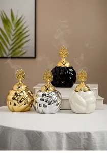 Modern minimalist ceramic incense burner with gold hollow lid, elegant home aroma decor.
