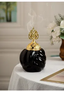 Modern minimalist ceramic incense burner details, elegant golden hollow lid design.