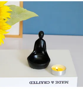 Gros plan detaille de la figurine zen en resine abstraite avec bougie chauffe-plat allumee.