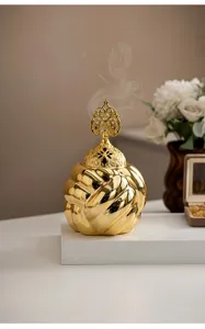 Detailed view of gold ceramic incense burner featuring intricate hollow lid and elegant design.