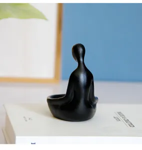 Vue détail figurine bougeoir zen en résine noire abstraite, décoration méditation moderne.