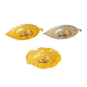 Close-up details of creative metal leaf incense holders featuring delicate snail figurines.