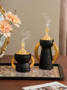Vista dettagliata del bruciatore d'incenso arabo in stile mediorientale con manici dorati.