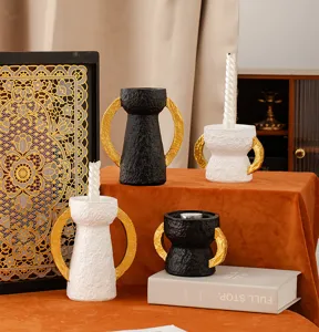 Dettaglio portacandela in resina, design con doppie orecchie dorate, stile decorativo.
