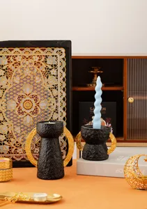 Dettagli di portacandele in resina nera e oro, elegante decorazione da tavola per casa.