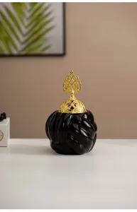 Detail view of the black ceramic incense burner featuring a decorative gold hollow lid setup.
