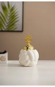 Detailed view of white ceramic braided ball incense burner with ornate gold lid.