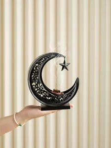 Metal crescent moon incense burner with hanging star detail, elegant black hollow design for home.