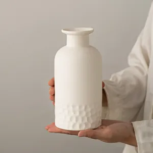 Détail de vase en céramique blanche avec fond texturé et forme élégante pour déco gros plan