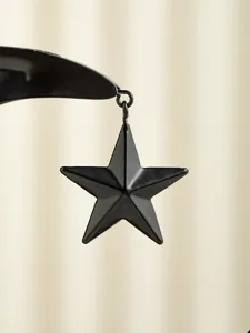 Close-up of black metal star pendant, detail view of Arabic incense burner accessory part.