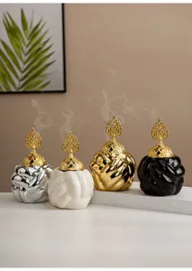 Modern ceramic incense burner with gold lid, elegant knot design for home decor detail view.