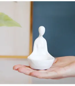Gros plan détail du bougeoir figurine méditation abstrait en résine blanche avec beau travail.