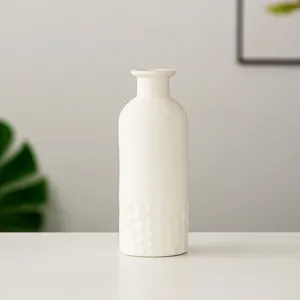Gros plan d'un vase en céramique blanche minimaliste avec fond texturé pour votre décoration.
