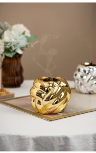 Nahaufnahme des modernen skandinavischen goldenen Weihrauchbrenners mit eleganter Metallstruktur.