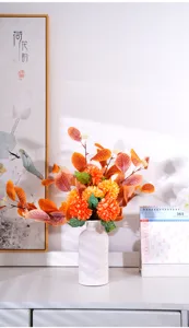 Vue rapprochée d'un vase en céramique blanche avec un arrangement de fleurs artificielles.