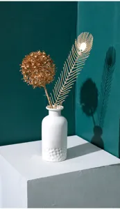Vase en céramique blanche style nordique avec arrangement floral doré, détail déco entrée.