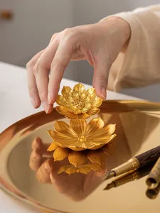 Dettaglio raffinato del bruciatore di incenso in metallo lotus dorato per aromaterapia.