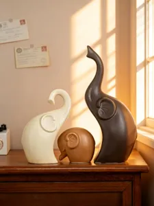 Detail shot of ceramic elephant family ornaments, minimalist home desktop decor piece.