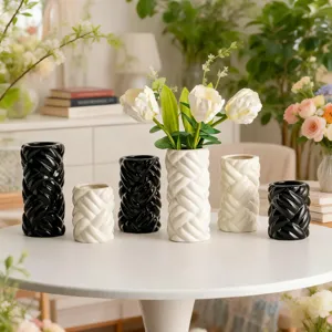 Detailed view of modern minimalist ceramic woven vases in black and white finish.