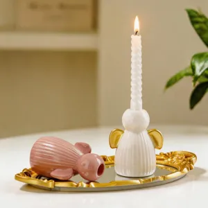 Detail bougeoir ange en ceramique, rose et blanc avec ailes dores sur plateau miroir.