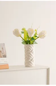 Modern minimalist white ceramic woven vase with artificial tulips for elegant home decor.