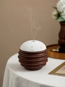 Detailaufnahme moderner Keramik Weihrauchbrenner kugelförmig mit geripptem Sockel und weißer Kappe.