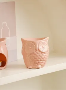 Pink ceramic owl candle holder detail view, cute home decor ornament for living room table.