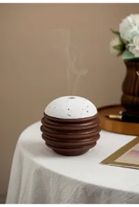 Detailansicht des kreativen kugelförmigen Räucherfasses mit geripptem braunem Sockel und gesprenkelter.