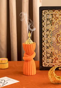 Arabic style resin incense burner with orange flocked wrapped design and golden metal lid.