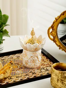 Detailed shot of an elegant golden Arabic incense burner with floral relief details.