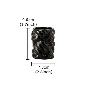 Detail view of black ceramic braided cylinder vase, showing compact modern decor size.