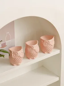 Detailed view of cute pink ceramic owl aroma diffuser candle holder for cozy home decor shelf.