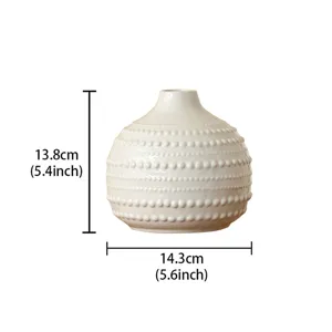 Vue détaillée d'un vase en céramique blanche avec motif perlé texturé pour décoration intérieure.
