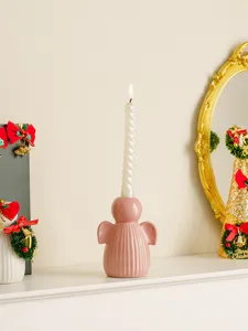Vue detaillee du bougeoir ange en ceramique rose avec bougie spirale pour decoration.
