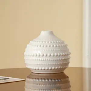 Vase en céramique blanche nordique avec perles texturées pour détail de déco.