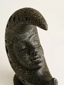 Close-up detail shot of the vintage resin moon face sculpture with unique black and gold finish.