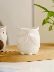 White ceramic owl aroma burner and candle holder for home decor, relaxing ambient lighting.