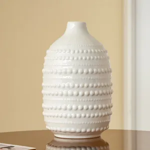 Détail de vase en céramique blanche nordique, surface texturée à points pour la décoration intérieure.