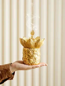 Golden lotus incense burner detail view showing exquisite floral relief and elegant metallic finish.